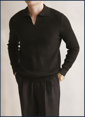 Homme portant un polo en maille noir à col ouvert, coupe ajustée, avec un pantalon noir élégant — look minimaliste et masculin haut de gamme.