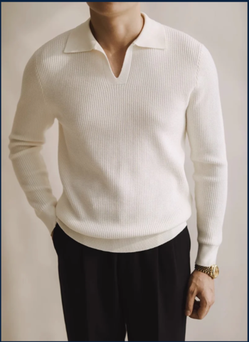 Polo en maille blanc cassé à col ouvert, porté avec un pantalon noir, incarnant un style épuré, moderne et intemporel pour homme.